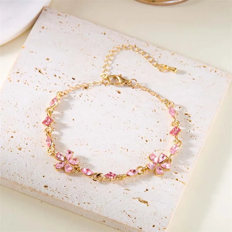 Bracelet doré avec cristaux et fleurs roses