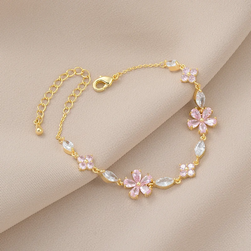 Bracelet doré avec cristaux et fleurs roses