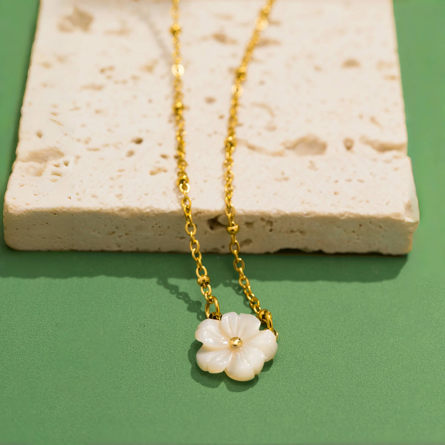 Collier doré avec fleur blanche