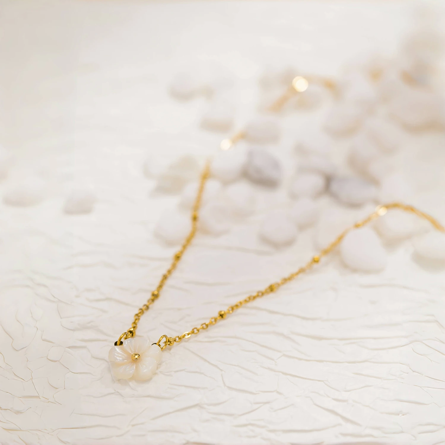 Collier doré avec fleur blanche