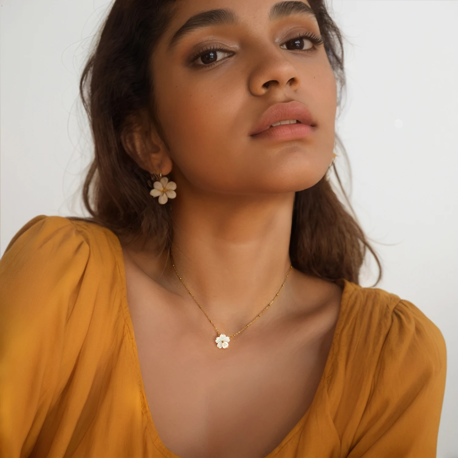 Collier doré avec fleur blanche